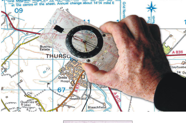 A hand holding a compass over a map